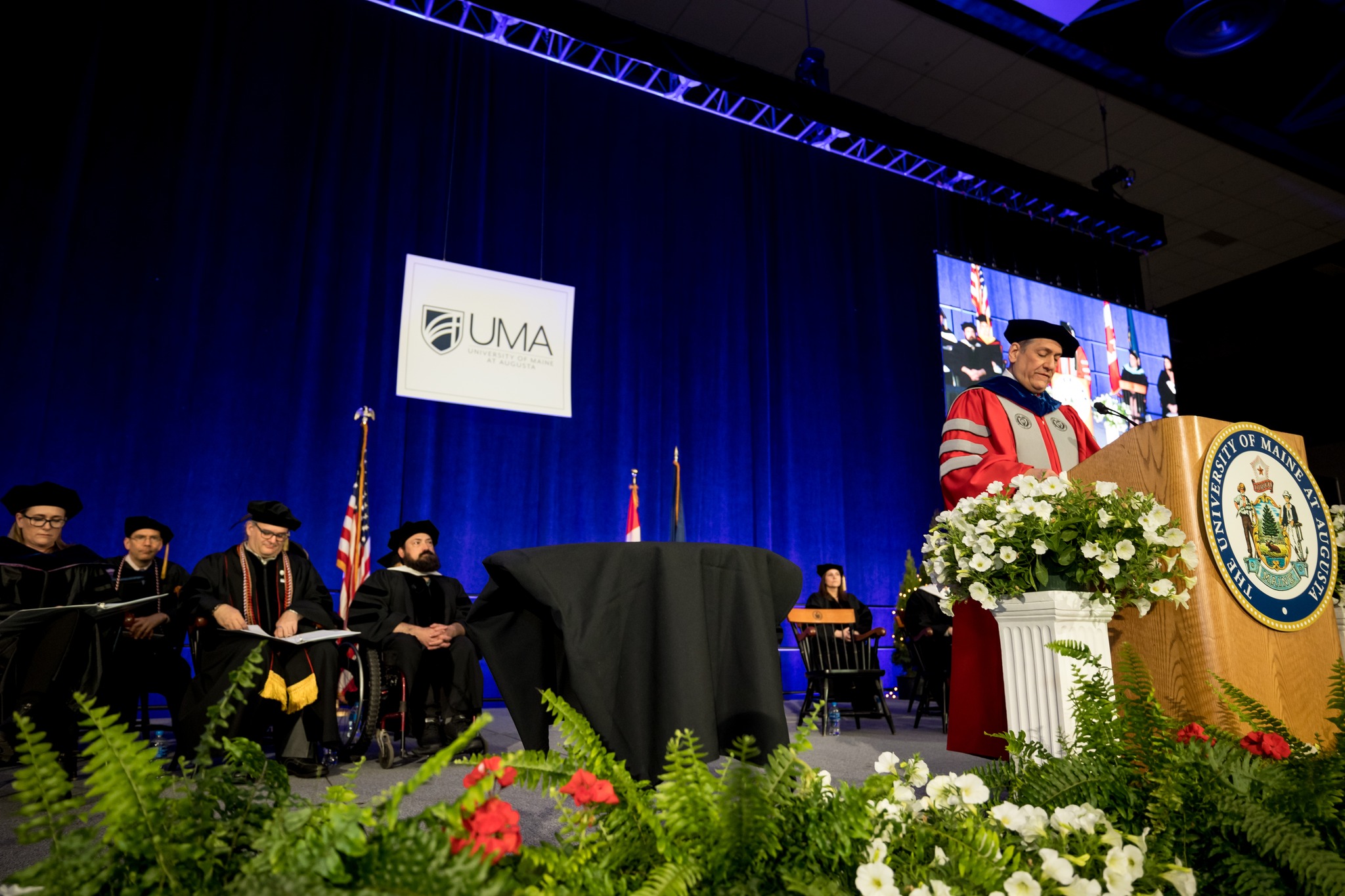 UMA Interim President, keynote speaker and several others on stage at 2023 UMA graduation